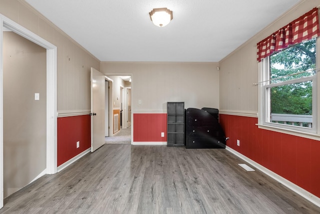 305 Barry Dr, Clarksville, TN 37040 - empty room with wood finished floors, ornamental molding, wood walls, and a wainscoted wall