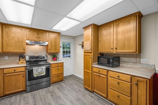 305 Barry Dr, Clarksville, TN 37040 - kitchen with stainless steel range with electric cooktop, under cabinet range hood, black microwave, light countertops, and backsplash