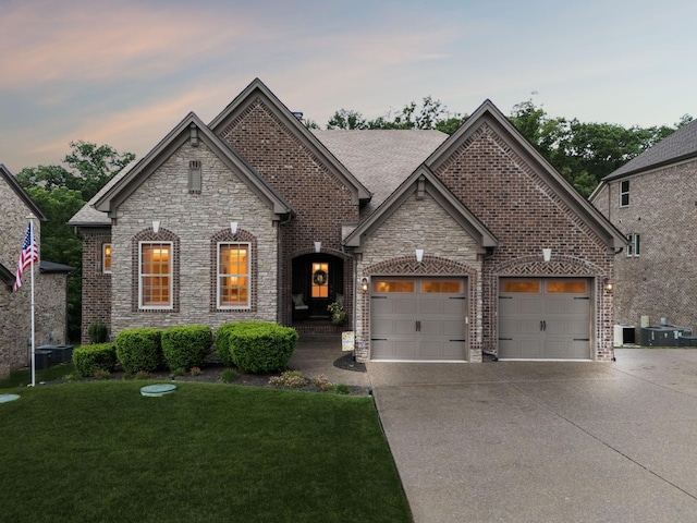 2229 Arbor Pointe Way, Hermitage, TN 37076 - french country inspired facade featuring driveway, a lawn, a garage, stone siding, and brick siding