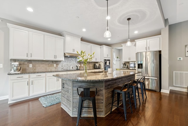 2229 Arbor Pointe Way, Hermitage, TN 37076 - kitchen with stainless steel appliances, an island with sink, dark wood-type flooring, a kitchen breakfast bar, and stone counters