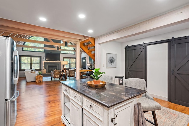 1455 Shell Rd, Goodlettsville, TN 37072 - kitchen with freestanding refrigerator, open floor plan, a barn door, a breakfast bar, and light wood-style floors