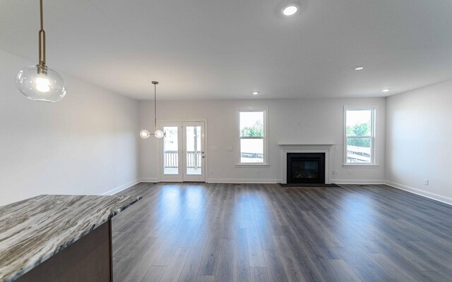 7938 Pine St, Fairview, TN 37062 - unfurnished living room featuring dark wood-style flooring, a glass covered fireplace, and recessed lighting