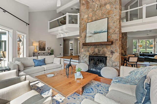 8530 Saundersville Rd, Mount Juliet, TN 37122 - living room featuring high vaulted ceiling, beamed ceiling, wood finished floors, and a stone fireplace