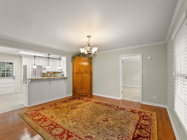 1746 Harton Blvd, Tullahoma, TN 37388 - unfurnished dining area with a chandelier, wood finished floors, crown molding, healthy amount of natural light, and a textured ceiling