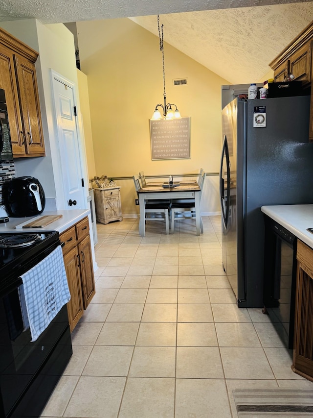 11013 Nevada Ave, Smyrna, TN 37167 - kitchen featuring black appliances, vaulted ceiling, a textured ceiling, light tile patterned flooring, and light countertops