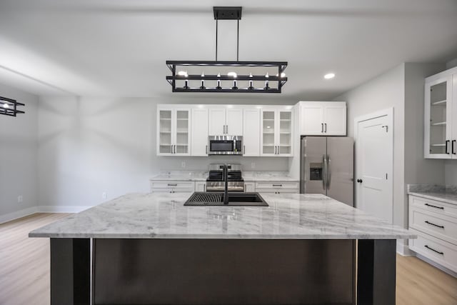 106 5th Ave N, Decherd, TN 37324 - kitchen with appliances with stainless steel finishes, light wood-type flooring, glass insert cabinets, a large island, and recessed lighting