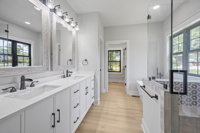 106 5th Ave N, Decherd, TN 37324 - full bath featuring double vanity, wood finished floors, a tile shower, and recessed lighting