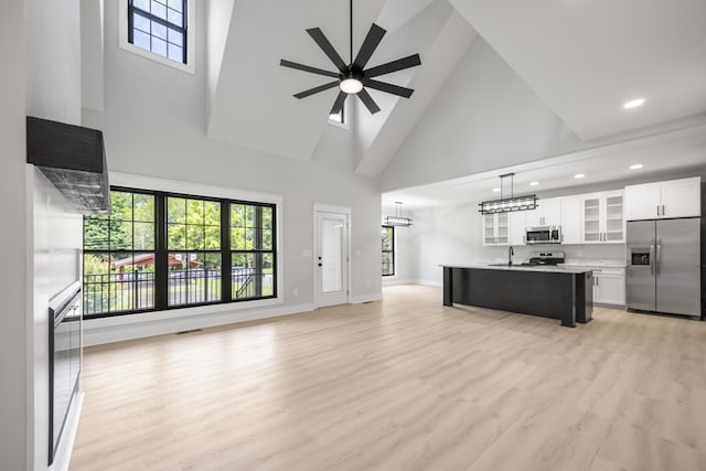 106 5th Ave N, Decherd, TN 37324 - unfurnished living room with high vaulted ceiling, healthy amount of natural light, light wood-style flooring, and recessed lighting