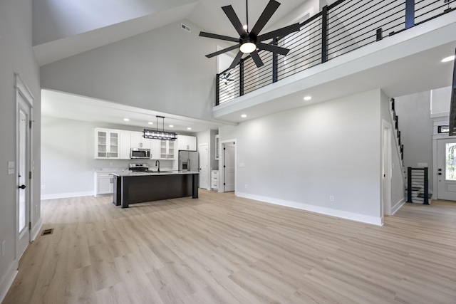 106 5th Ave N, Decherd, TN 37324 - unfurnished living room featuring a high ceiling, ceiling fan, light wood-style floors, and recessed lighting