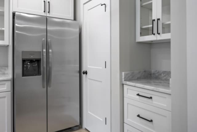 106 5th Ave N, Decherd, TN 37324 - kitchen with stainless steel fridge with ice dispenser, white cabinetry, light stone countertops, and glass insert cabinets