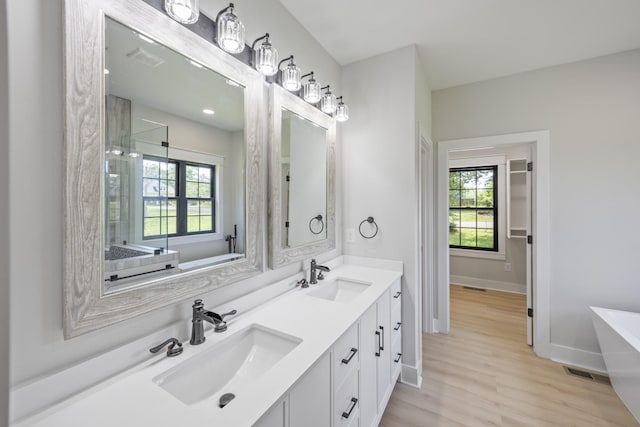 106 5th Ave N, Decherd, TN 37324 - bathroom with double vanity, a freestanding bath, wood finished floors, and a shower
