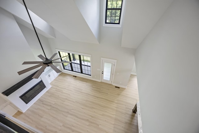 106 5th Ave N, Decherd, TN 37324 - unfurnished living room featuring wood finished floors, a towering ceiling, and ceiling fan