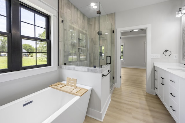 106 5th Ave N, Decherd, TN 37324 - bathroom with a freestanding tub, vanity, a shower stall, and wood finished floors