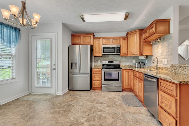 1107 Moreno Ln, Lewisburg, TN 37091 - kitchen with stainless steel appliances, decorative backsplash, a chandelier, light stone countertops, and pendant lighting