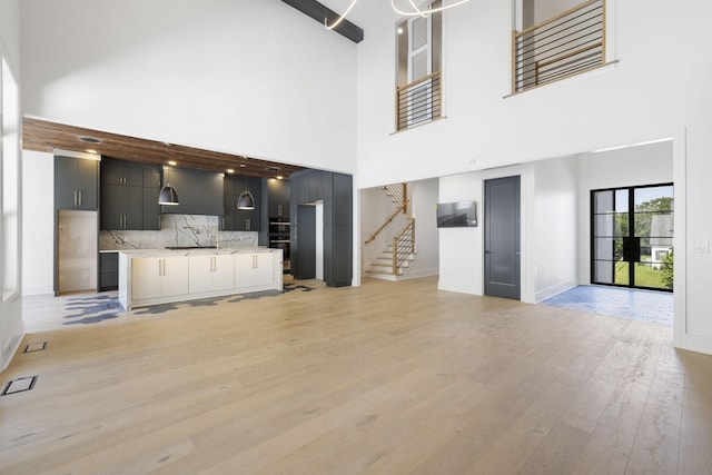 1884 Barnstaple Ln, Brentwood, TN 37027 - unfurnished living room featuring stairs, a towering ceiling, and light wood-style flooring
