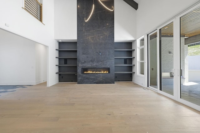 1884 Barnstaple Ln, Brentwood, TN 37027 - unfurnished living room with a towering ceiling, a high end fireplace, wood finished floors, and built in features