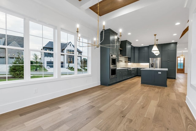 3244 Arundel Ln, Thompsons Station, TN 37179 - kitchen featuring stainless steel appliances, light wood finished floors, light countertops, backsplash, and decorative light fixtures