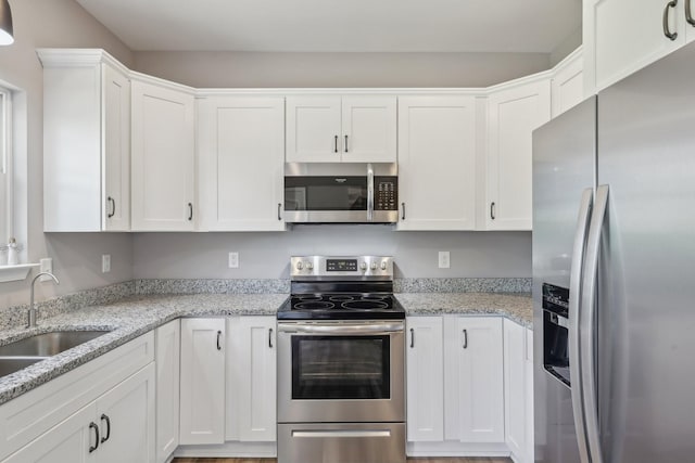 1219 Oak Grove Rd, Dickson, TN 37055 - kitchen with stainless steel appliances, white cabinets, and light stone countertops