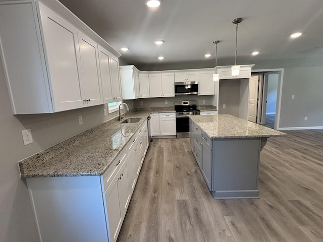 760 Hanestown Rd, Lafayette, TN 37083 - kitchen with stainless steel appliances, light wood-type flooring, white cabinets, a center island, and recessed lighting