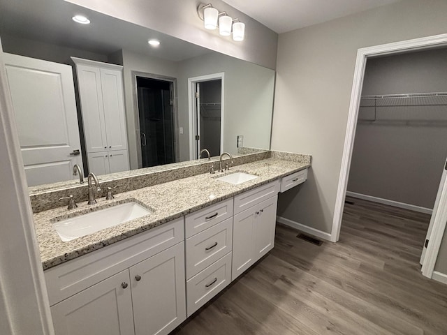 760 Hanestown Rd, Lafayette, TN 37083 - bathroom with double vanity, wood finished floors, a walk in closet, and recessed lighting