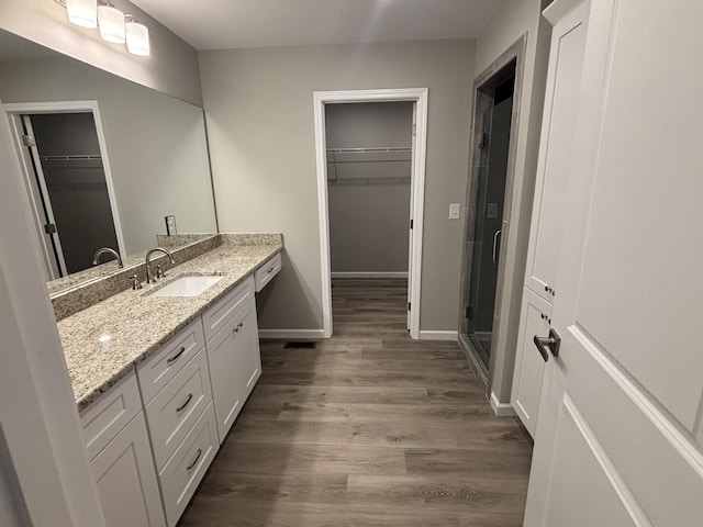 760 Hanestown Rd, Lafayette, TN 37083 - full bathroom with vanity, a walk in closet, wood finished floors, and a shower stall