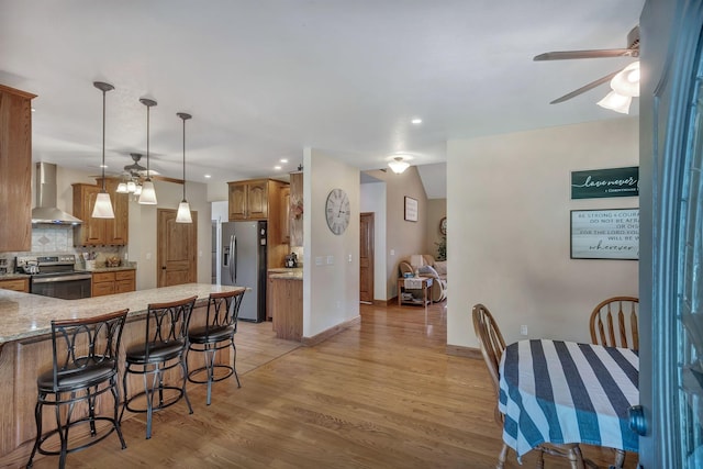 3534 Summertown Hwy, Summertown, TN 38483 - kitchen with ceiling fan, stainless steel appliances, wall chimney exhaust hood, light wood finished floors, and a peninsula