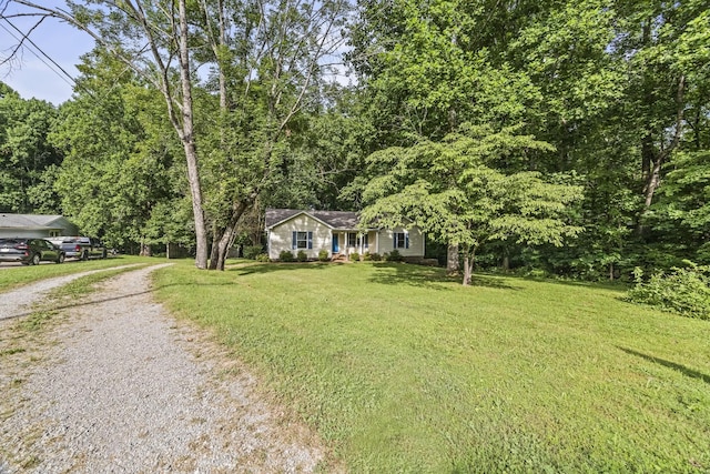 7125 Sutton Pl, Fairview, TN 37062 - view of front facade featuring gravel driveway, a front yard, and a forest view