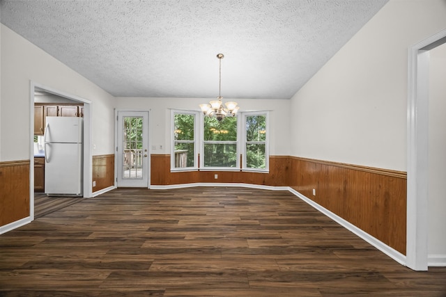 7125 Sutton Pl, Fairview, TN 37062 - unfurnished dining area with wainscoting, a textured ceiling, dark wood-type flooring, a chandelier, and wooden walls
