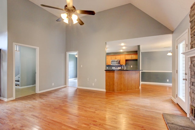 4425 Taylor Hall Ln, Adams, TN 37010 - unfurnished living room featuring high vaulted ceiling, ceiling fan, light wood-style flooring, and a stone fireplace