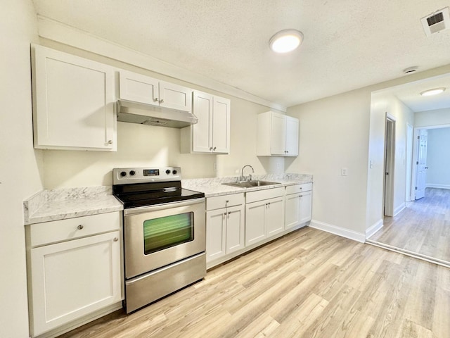 810 Roanoke Ave, Chattanooga, TN 37404 - kitchen with stainless steel electric range, under cabinet range hood, light wood-style flooring, white cabinets, and a textured ceiling