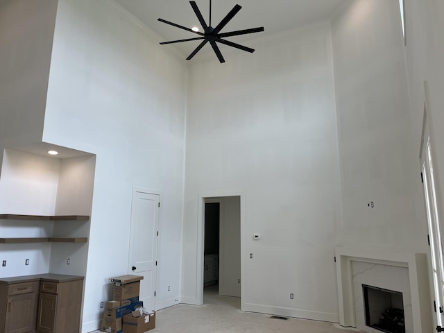 133 Scarsdale Dr S, Hendersonville, TN 37075 - unfurnished living room featuring a towering ceiling, a ceiling fan, crown molding, and a premium fireplace
