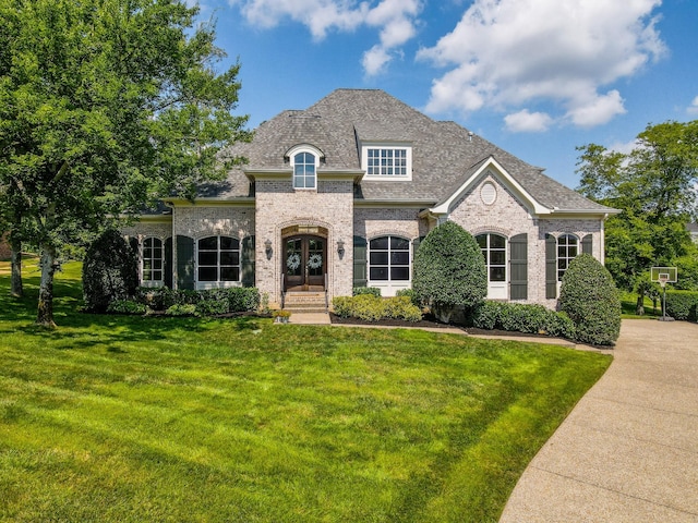 9516 Wicklow Rd, Brentwood, TN 37027 - french country style house featuring a front yard, brick siding, roof with shingles, and french doors