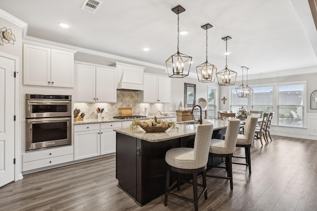 679 Overton Way, Spring Hill, TN 37174 - kitchen featuring stainless steel appliances, crown molding, a chandelier, a kitchen island with sink, and a kitchen bar