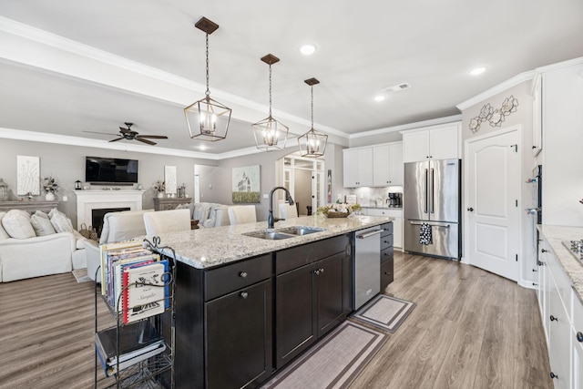 679 Overton Way, Spring Hill, TN 37174 - kitchen featuring appliances with stainless steel finishes, a ceiling fan, white cabinets, light wood-type flooring, and an island with sink