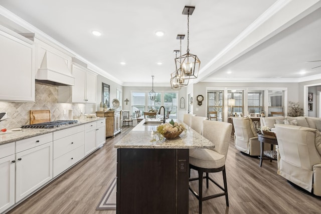679 Overton Way, Spring Hill, TN 37174 - kitchen with open floor plan, wood finished floors, a kitchen bar, white cabinetry, and decorative backsplash