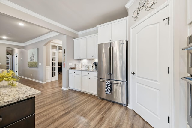 679 Overton Way, Spring Hill, TN 37174 - kitchen featuring high quality fridge, light wood-type flooring, arched walkways, white cabinetry, and ornamental molding