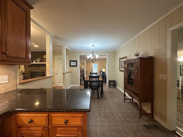 412 Winwood Dr, Lebanon, TN 37087 - kitchen featuring a peninsula, a chandelier, backsplash, dark tile patterned flooring, and crown molding