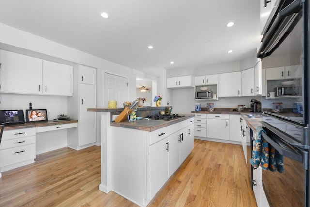 3899 Sadlersville Rd, Adams, TN 37010 - kitchen featuring light wood-style floors, stainless steel appliances, recessed lighting, dark countertops, and white cabinetry