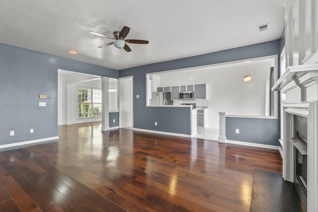 3405 Old Anderson Rd Unit 203, Antioch, TN 37013 - unfurnished living room with ceiling fan, a fireplace, ornate columns, and dark wood-style flooring