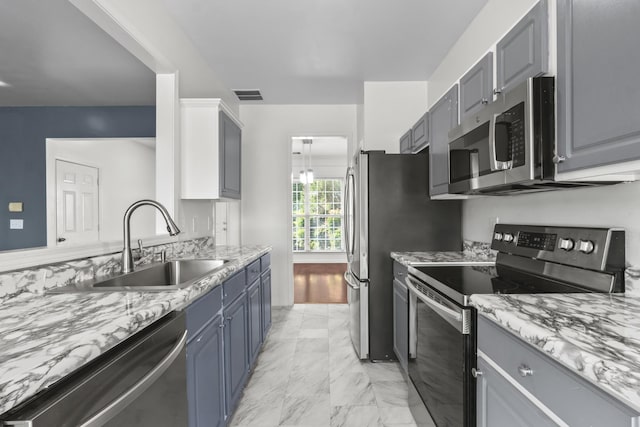 3405 Old Anderson Rd Unit 203, Antioch, TN 37013 - kitchen with stainless steel appliances, light marble finish floors, light stone counters, blue cabinets, and gray cabinetry