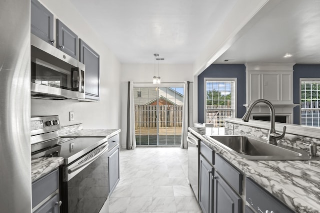 3405 Old Anderson Rd Unit 203, Antioch, TN 37013 - kitchen with appliances with stainless steel finishes, light marble finish floors, gray cabinets, light stone countertops, and decorative light fixtures