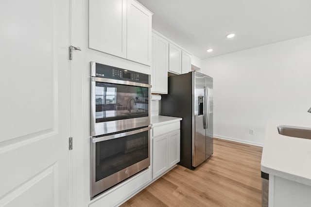 2337 Williamsport Lndg, Columbia, TN 38401 - kitchen featuring appliances with stainless steel finishes, light wood-style floors, light countertops, white cabinets, and recessed lighting
