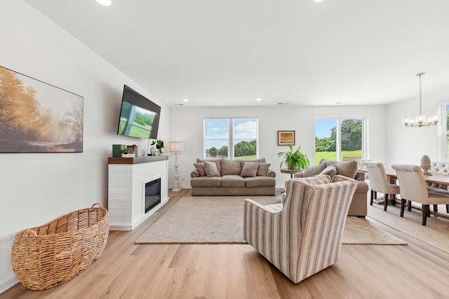 2337 Williamsport Lndg, Columbia, TN 38401 - living area featuring light wood-style floors, a glass covered fireplace, recessed lighting, and a chandelier