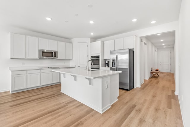 2337 Williamsport Lndg, Columbia, TN 38401 - kitchen with stainless steel appliances, recessed lighting, white cabinets, a kitchen island with sink, and a breakfast bar area