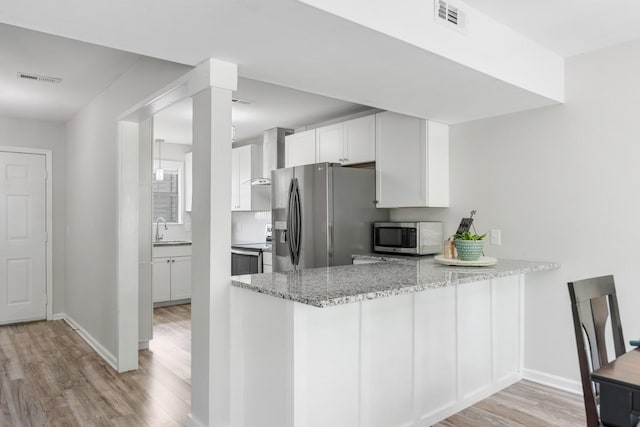 117 Maple Way N, Hendersonville, TN 37075 - kitchen with stainless steel appliances, light wood finished floors, white cabinets, light stone counters, and a peninsula