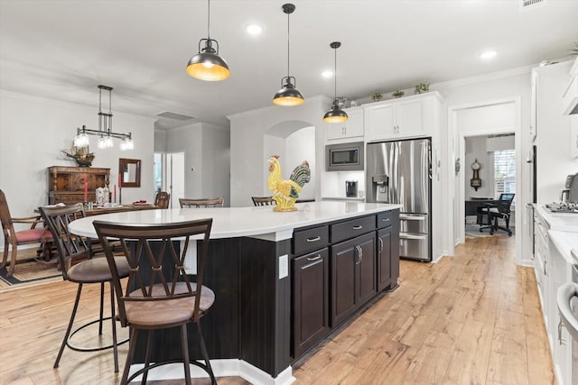1055 Sumner Grv, Spring Hill, TN 37174 - kitchen featuring appliances with stainless steel finishes, light countertops, light wood finished floors, white cabinetry, and ornamental molding