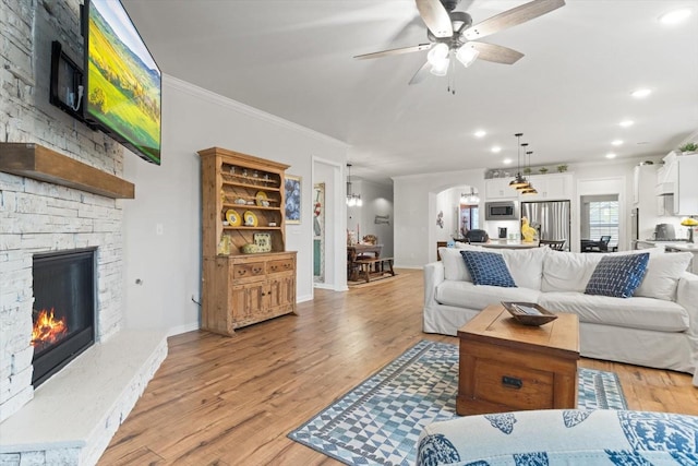 1055 Sumner Grv, Spring Hill, TN 37174 - living area with ceiling fan, arched walkways, ornamental molding, a stone fireplace, and light wood-style flooring