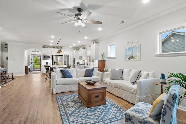 1055 Sumner Grv, Spring Hill, TN 37174 - living room featuring a ceiling fan, arched walkways, light wood-style flooring, ornamental molding, and recessed lighting