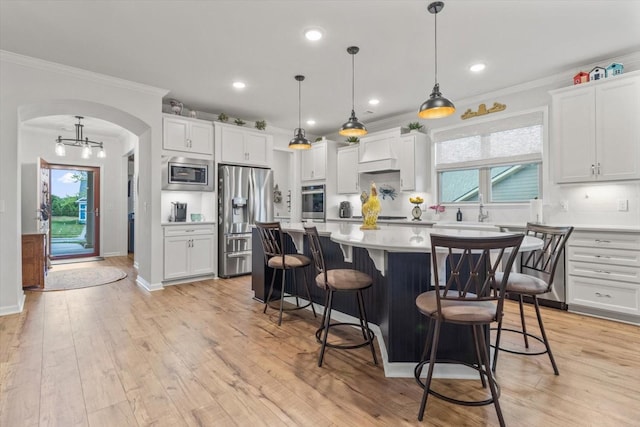 1055 Sumner Grv, Spring Hill, TN 37174 - kitchen with appliances with stainless steel finishes, arched walkways, light countertops, crown molding, and a kitchen island