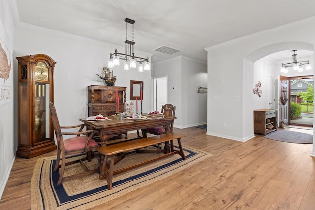 1055 Sumner Grv, Spring Hill, TN 37174 - dining space featuring arched walkways, light wood-type flooring, ornamental molding, and a chandelier